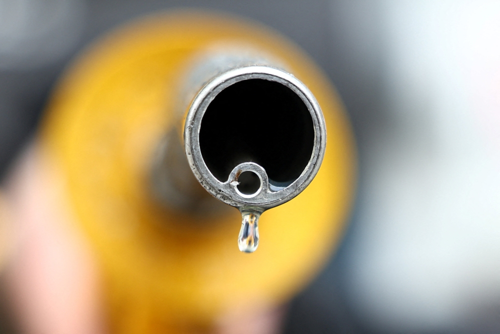 A man holds a fuel nozzle at a petrol station on March 25, 2026. — Reuters pic