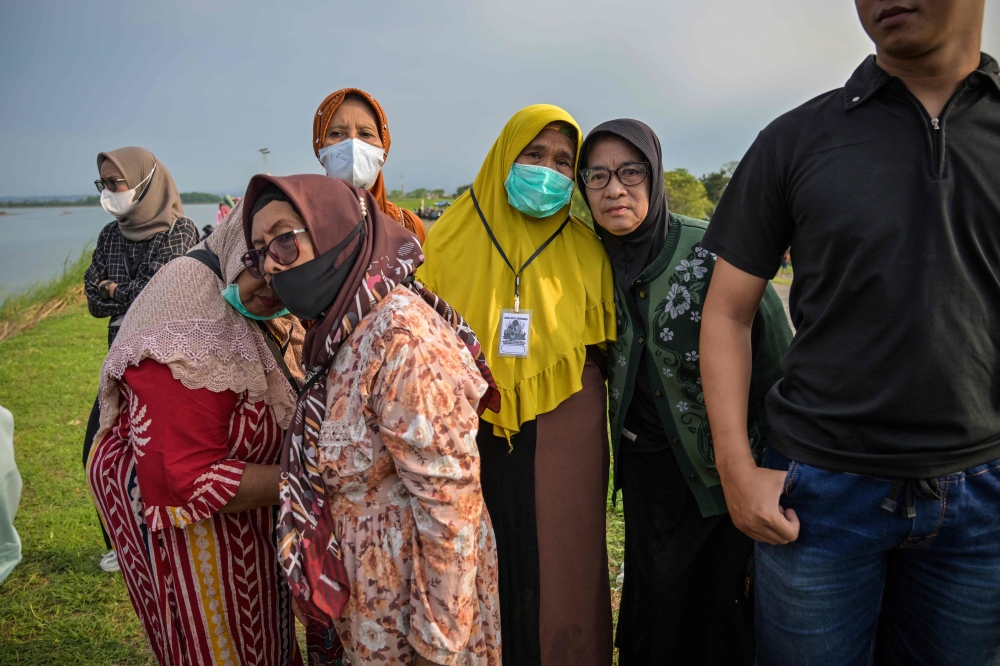 Residents affected by the Lapindo mudflow gather with environmental activists to offers prayers at the embankment of the mud volcano area, marking 20 years since a gas exploration accident triggered a mud flow that inundated more than a dozen villages and permanently displaced tens of thousands of people in Porong, Sidoarjo, East Java province on May 29, 2026. — AFP pic