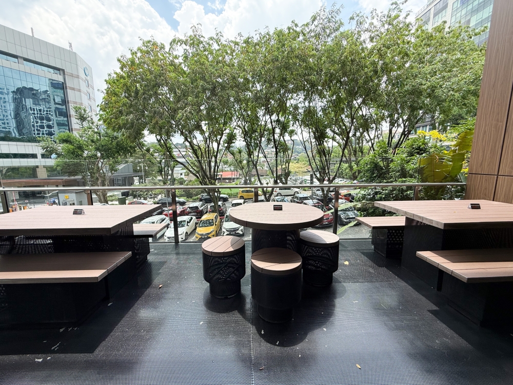 Tables and chairs are found all over The Five and these ones offer a view of the goings-on  below. —Picture by Lee Khang Yi