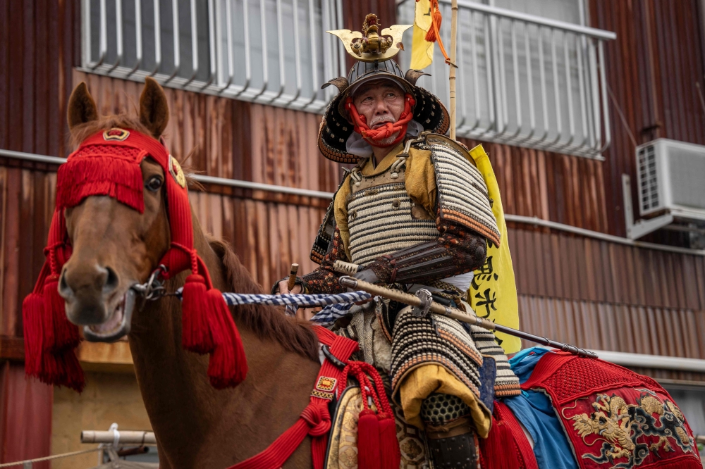 This picture taken on May 24, 2026 shows Mitsukiyo Monma leaving his house for a parade during the Soma Nomaoi festival in Minamisoma, Fukushima prefecture. — AFP pic