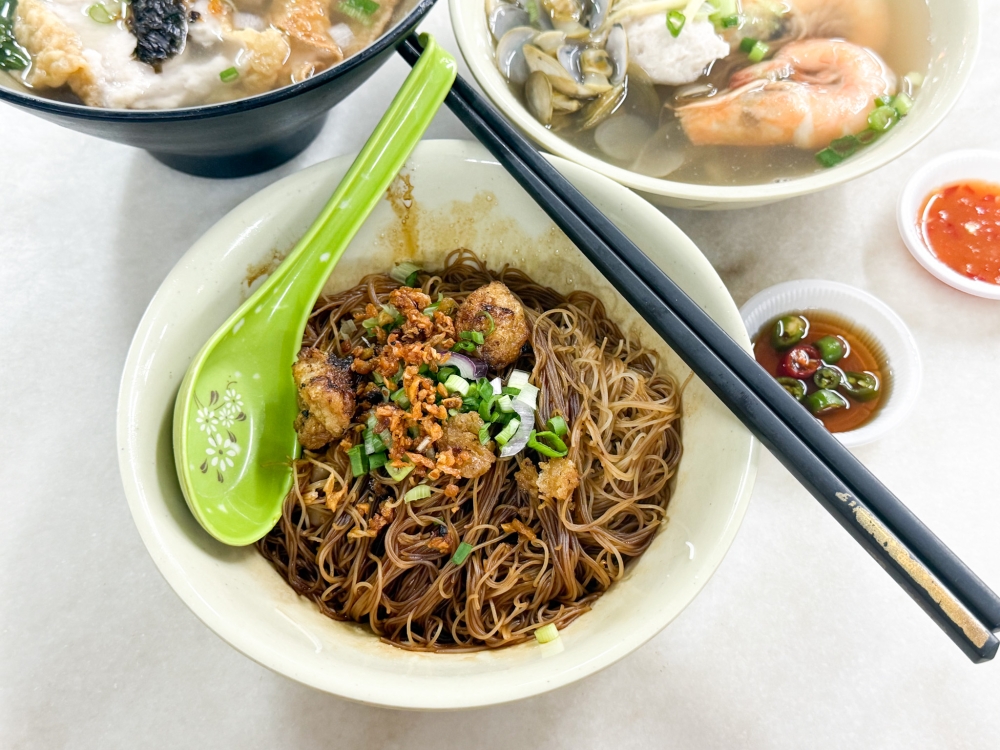 A bowl of their dry noodles is decadent: dark-coloured noodle strands laced with lard and topped with fluffy lard fritters plus fried garlic. — Picture by Lee Khang Yi