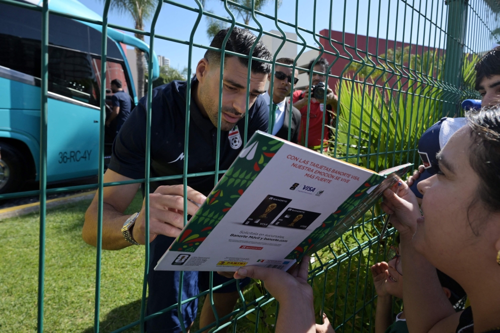 Iran’s forward Mehdi Taremi signs autographs for a fan outside the Marriott Hotel before leaving for a training session in Tijuana, Mexico, on June 10, 2026, ahead of the 2026 Fifa World Cup football tournament. — AFP pic 