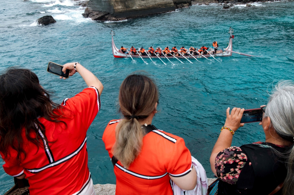 People watch as Tao indigenous rowers paddle their Ovayan along the coastline at Orchid Island, Taiwan during a voyage to the Batanes Islands of the Philippines on June 15, 2026. — AFP pic
