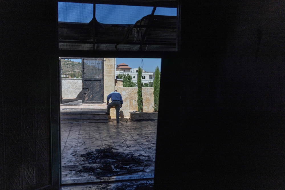A Palestinian man rinses the soles of his shoes from soot after inspecting the damage inside a mosque reportedly burnt by Israeli settlers over night, in the Israeli occupied West Bank village of Jiljlia, just north of the West Bank city of Ramallah on June 17, 2026. — AFP pic