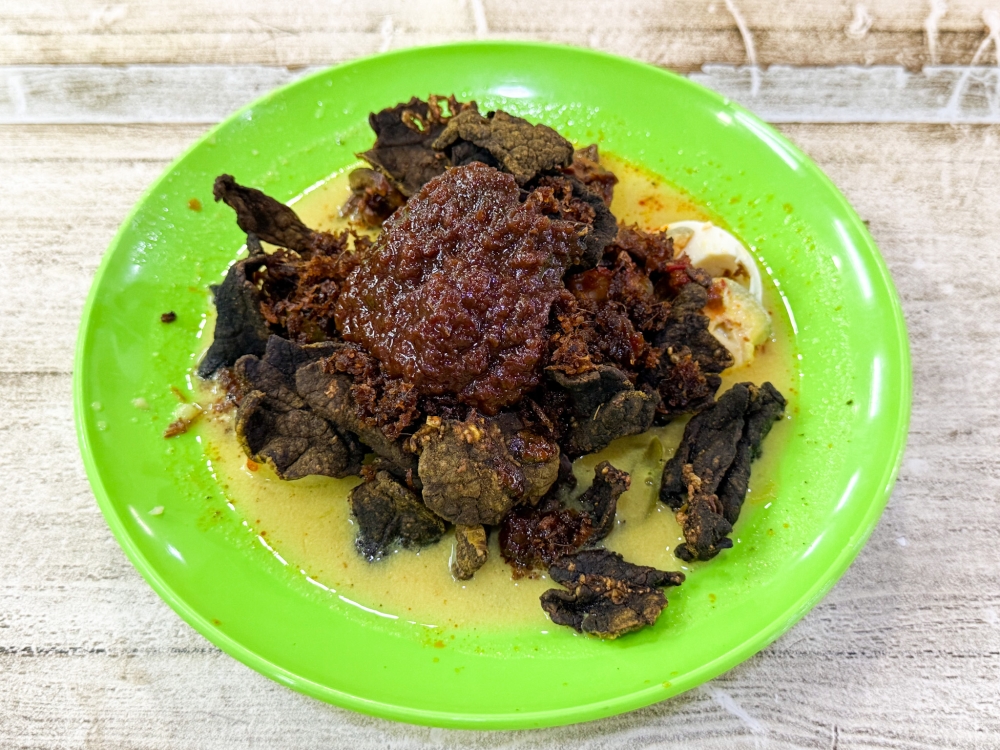 It’s not pretty food but keen eaters can pick out the crispy wafer thin ‘paru’ eaten like crisps with this ‘lontong’ topped with a dark red ‘sambal’. — Picture by Lee Khang Yi