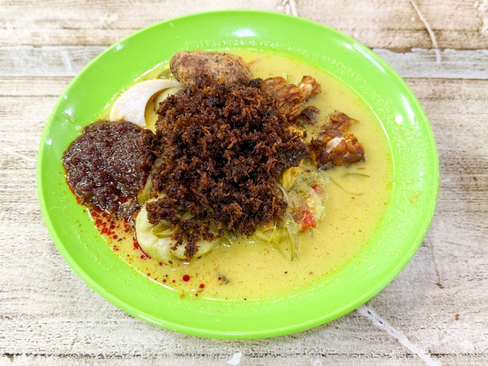 Under the blanket of ‘serunding’ and ‘sambal’, there’s ‘rendang daging’, ‘tempeh’ and ‘begedil’ with the ‘lontong’. — Picture by Lee Khang Yi