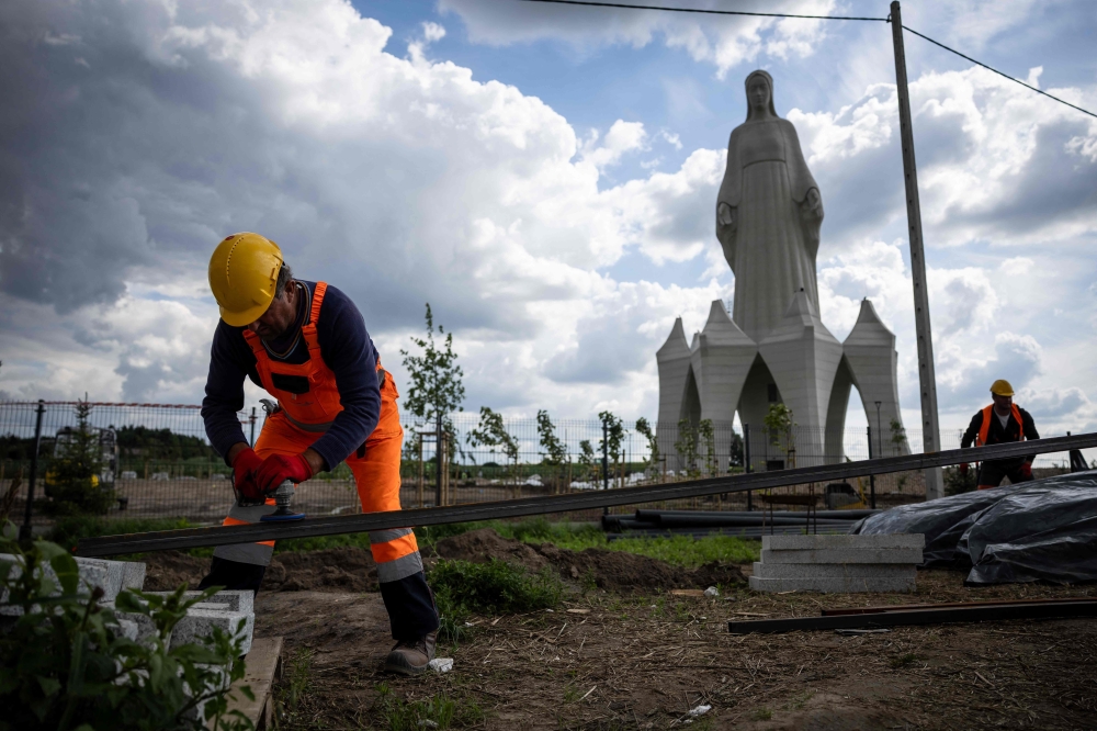 A worker is seen on the construction site where finishing works are being carried out on the statue of the Virgin Mary in Konotopie village, next to Torun, central Poland, on July 22, 2026. — AFP pic