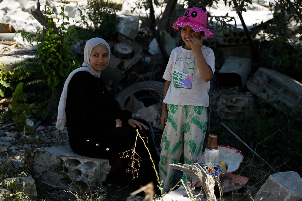 Young residents sit beside the ruins of their home in Zawtar al-Gharbiya on July 28, 2026, after the Lebanese army deployed to the southern village last week as part of a framework deal reached with Israel. — AFP pic