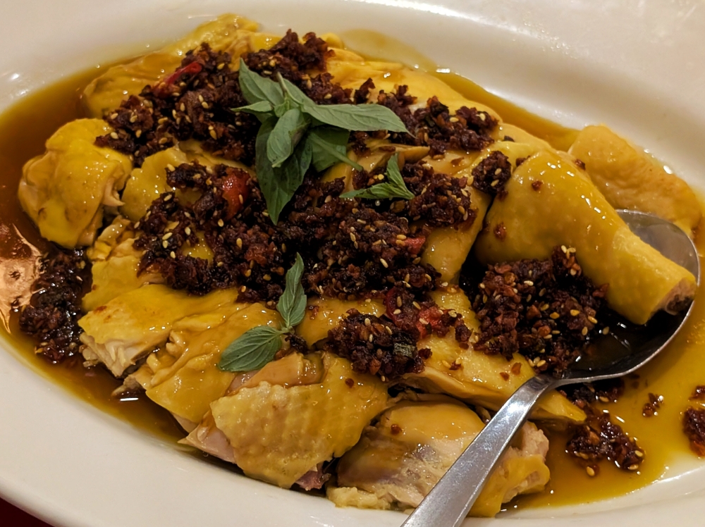 Even chicken isn’t done straightforwardly at De Maw. This dish combines white-cut chicken, three-cup chicken, and a Sichuan chilli-oil dressing that evokes ‘kou shui ji’. — Picture by Ethan Lau