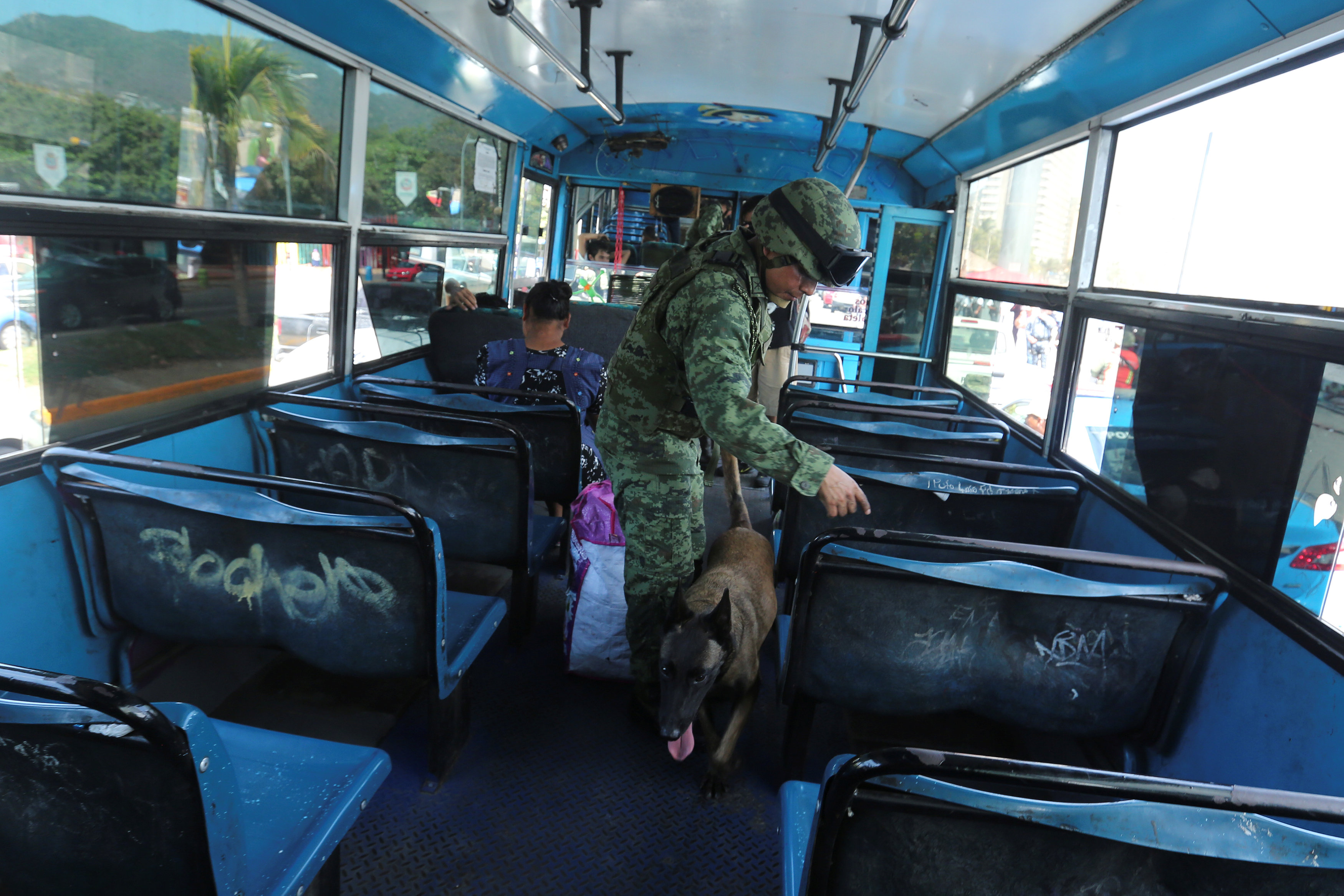 A soldier uses a sniffer dog to inspect a passenger bus for drugs and weapons at a checkpoint in the Miguel Aleman seafront boulevard in Acapulco, Mexico March 19, 2018. u00e2u20acu201d Reuters pic