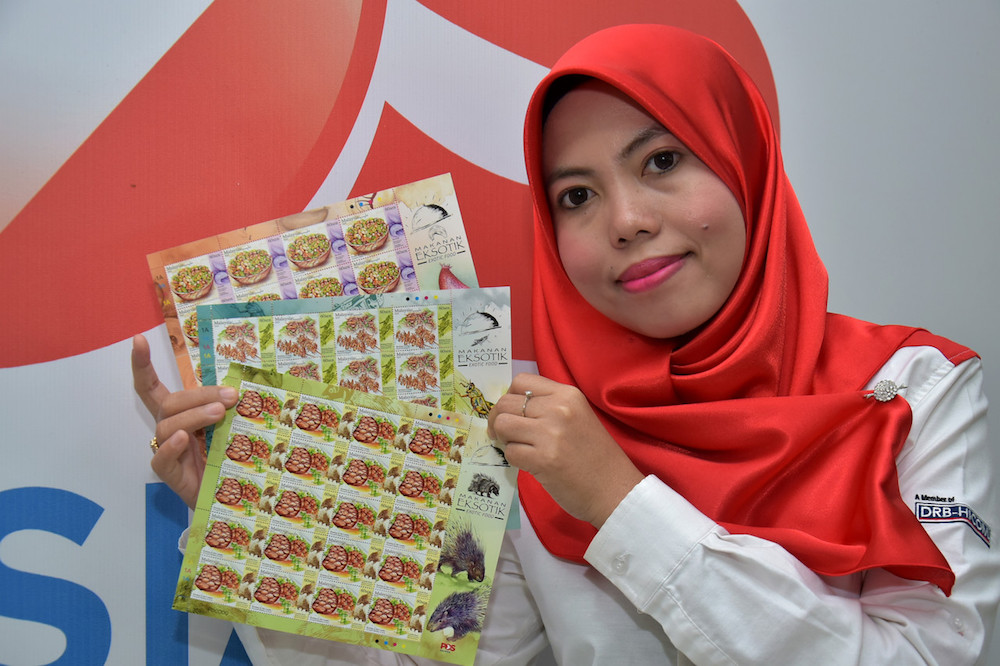 A Pos Malaysia representative holds the Exotic Food-themed postage stamps in Kuala Lumpur February 15, 2019. u00e2u20acu201d Bernama pic