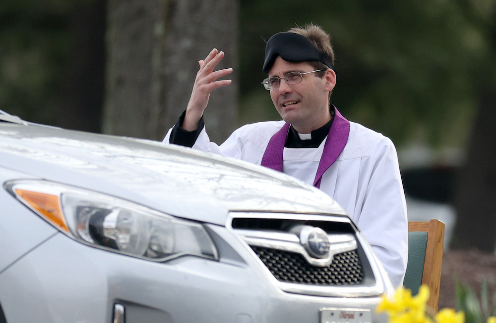 Father Scott Holmer of St. Edward the Confessor Catholic Church makes the sign of the cross after holding confession in the church parking lot on March 21, 2020 in Bowie, Maryland, US. — AFP pic