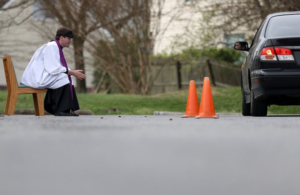 Father Scott Holmer of St. Edward the Confessor Catholic Church makes the sign of the cross after holding confession in the church parking lot on March 21, 2020 in Bowie, Maryland, US. u00e2u20acu201d AFP pic