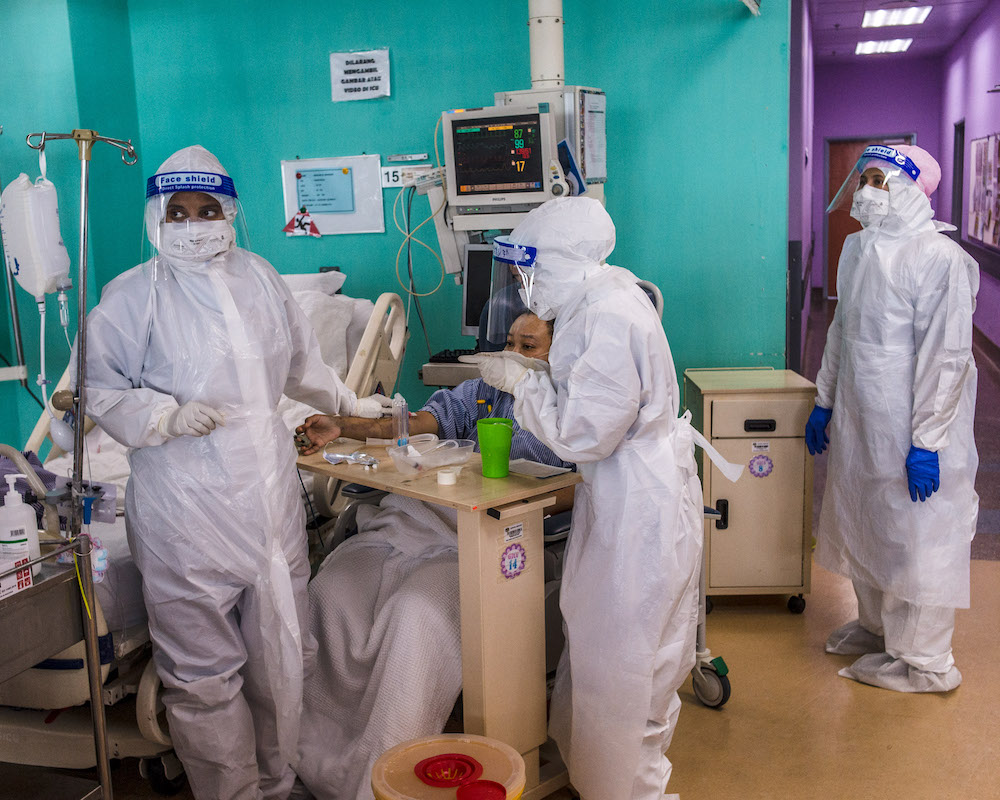 Health workers wearing PPE perform routine procedures on Covid-19 patients who have recovered and are not intubated in the ICU at Serdang Hospital. u00e2u20acu201d Picture by Shafwan Zaidon