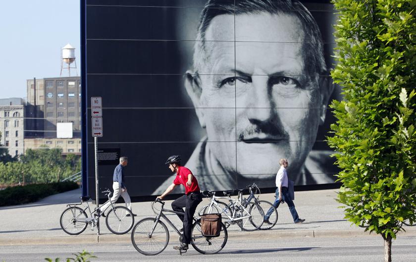 A cyclist rides past a giant portrait of Sir Tyrone Guthrie, creator of the Guthrie Theater in the heart of the old milling district in Minneapolis, Minnesota July 2, 2013.