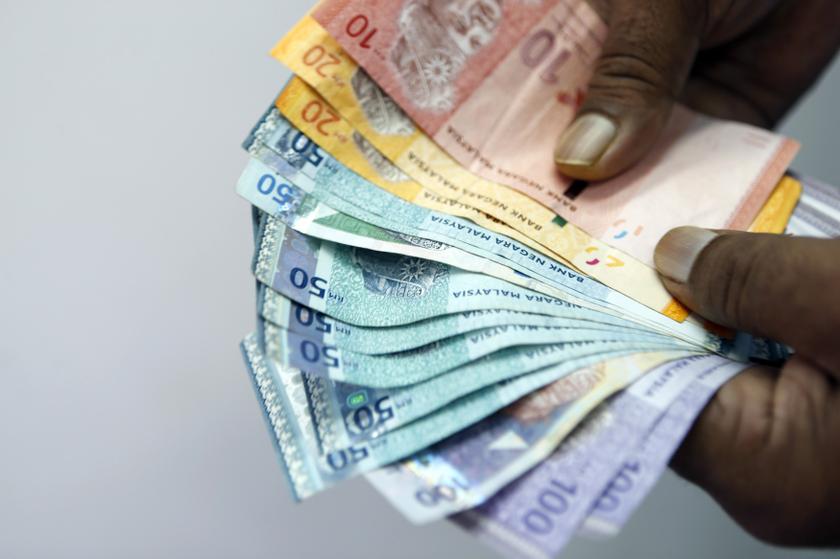 An employee counts money as he poses inside a money exchange centre in Kuala Lumpur October 22, 2013. u00e2u20acu201d Reuters pic